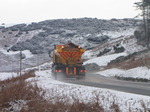 SX12146 Gritting truck driving through hillsides covered in snow.jpg
